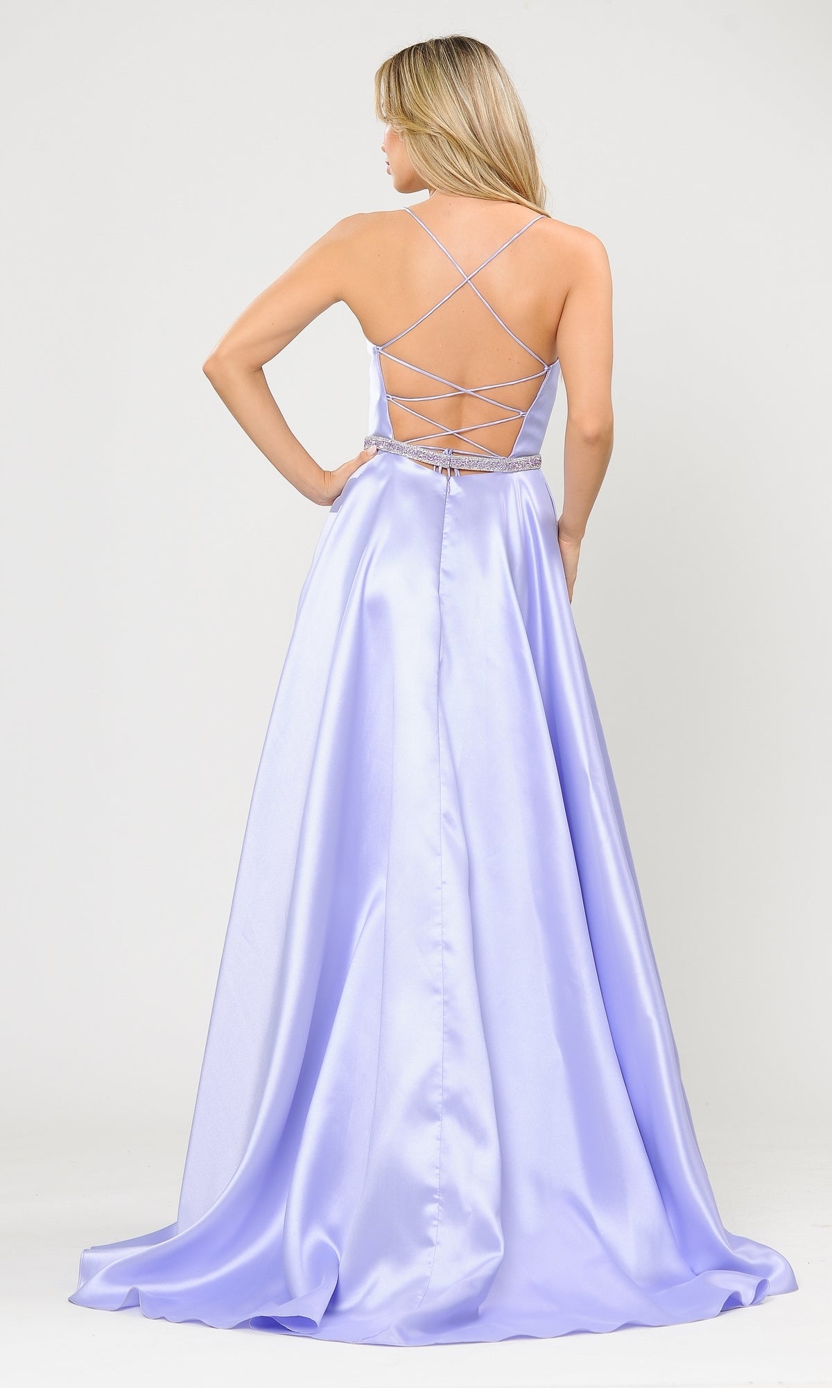Woman in the Strappy-Back Long Mikado A-Line Prom Dress 8688, featuring a floor-length silhouette, light lavender color, fitted waist, and open strappy back, stands facing away from the camera.